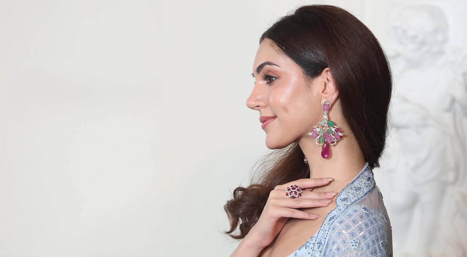 Woman wearing a pair of earrings with a white background