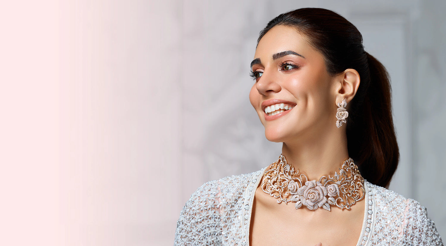 Woman wearing a necklace and earrings with a plain background