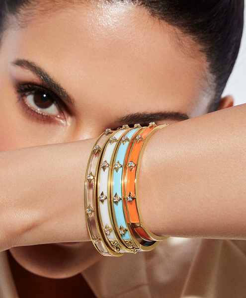 Close-up of a woman's arm wearing three colorful bangles with gold accents.