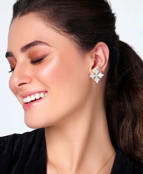 Woman wearing a floral earring with a plain background